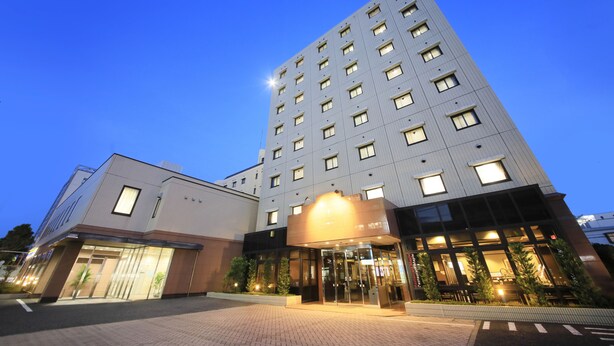 A modern hotel with a prominent entrance, multiple floors, and a clear sky. - Maple Inn Makuhari (Chiba)