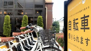 A bicycle rental station with a sign in Japanese. - Maple Inn Makuhari (Chiba)