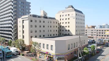 A multi-story hotel with a flat facade, large windows, and a corner location with a visible storefront.