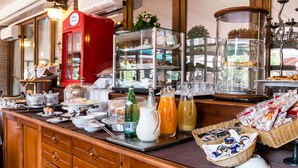 Un bufé de desayuno con diversas opciones de comida, bebidas y una máquina de café roja.