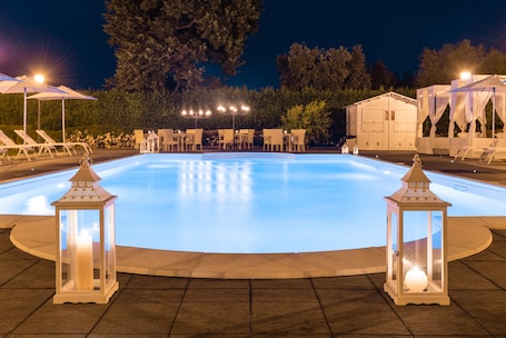 Una piscina al aire libre de temporada, sombrillas