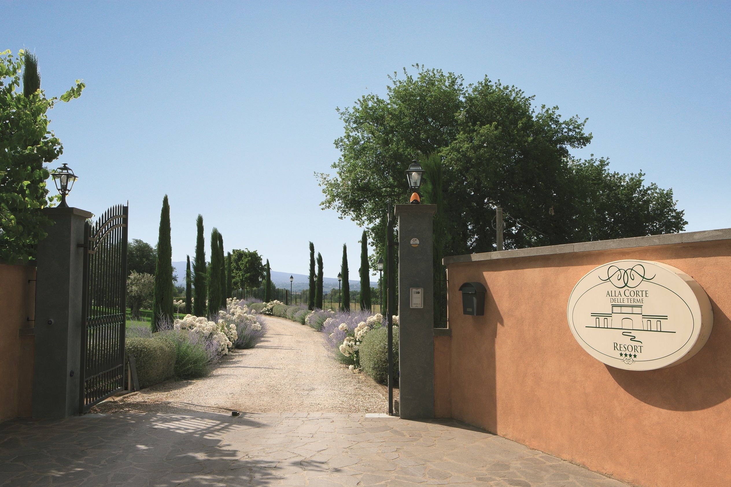 Un cancello che dà accesso a una proprietà, con un cartello che indica 'Alla Corte Delle Terme Resort'.