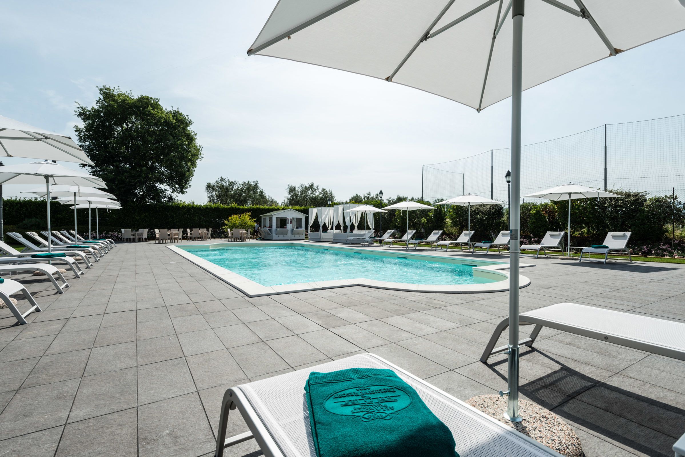 季节性开放的室外游泳池，池畔遮阳伞，日光浴躺椅