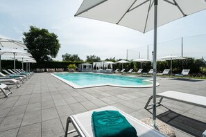 A poolside area with lounge chairs and umbrellas. - Phi Hotel Corte delle Terme (Viterbo)