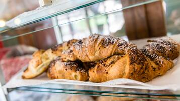 A display case with a variety of pastries, including croissants and other baked goods.
