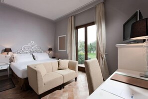 A hotel room with a bed, a sofa, a TV, and a desk. - Phi Hotel Corte delle Terme (Viterbo)