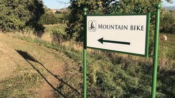 Schild für einen Mountainbike-Weg, Pfeil zeigt nach links.