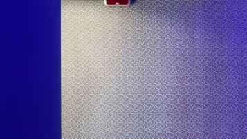 Una habitación moderna con un papel tapiz estampado, una mesa negra y una silla azul.