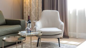 Un salón moderno con un sofá, una silla, una mesita redonda y una lámpara de pie.