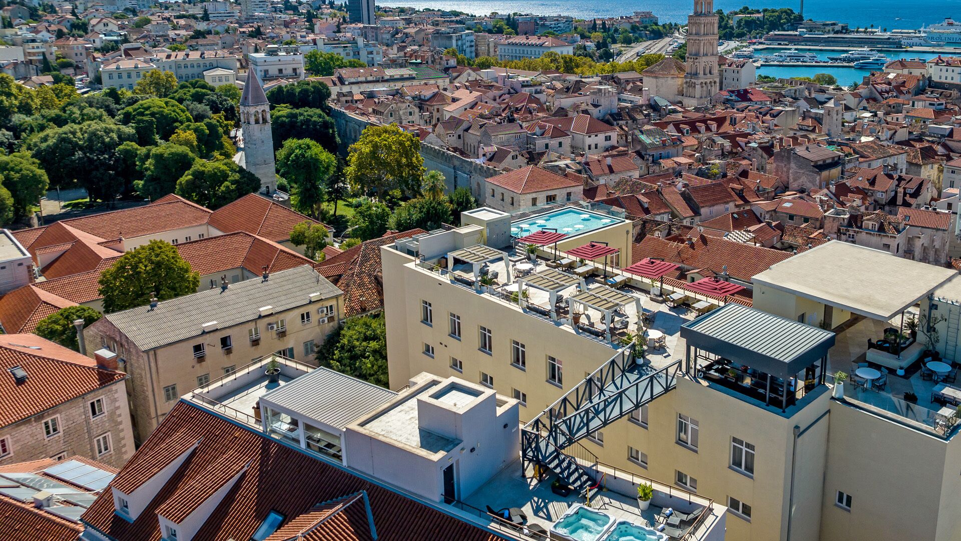 A hotel with a rooftop pool, a staircase, and a view of the cityscape.