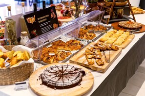 A buffet with various baked goods and pastries.