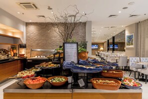 A buffet area with various food options and a sign about the Emperor Diocletian's morning ritual. - Cornaro Hotel (Split)