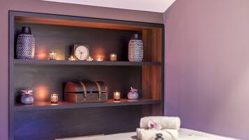 Un dormitorio con una cama, una estantería decorada y un reloj.
