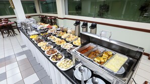 A buffet with various food items and utensils.