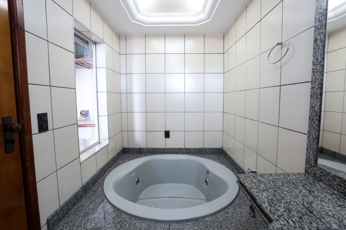 A modern bathroom with a freestanding bathtub, tiled walls, and a granite countertop.