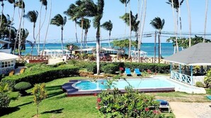 A resort with a swimming pool, palm trees, and a view of the ocean. - Costarena Beach Hotel (Las Terrenas)