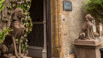 A stone dog statue and a door with a window.