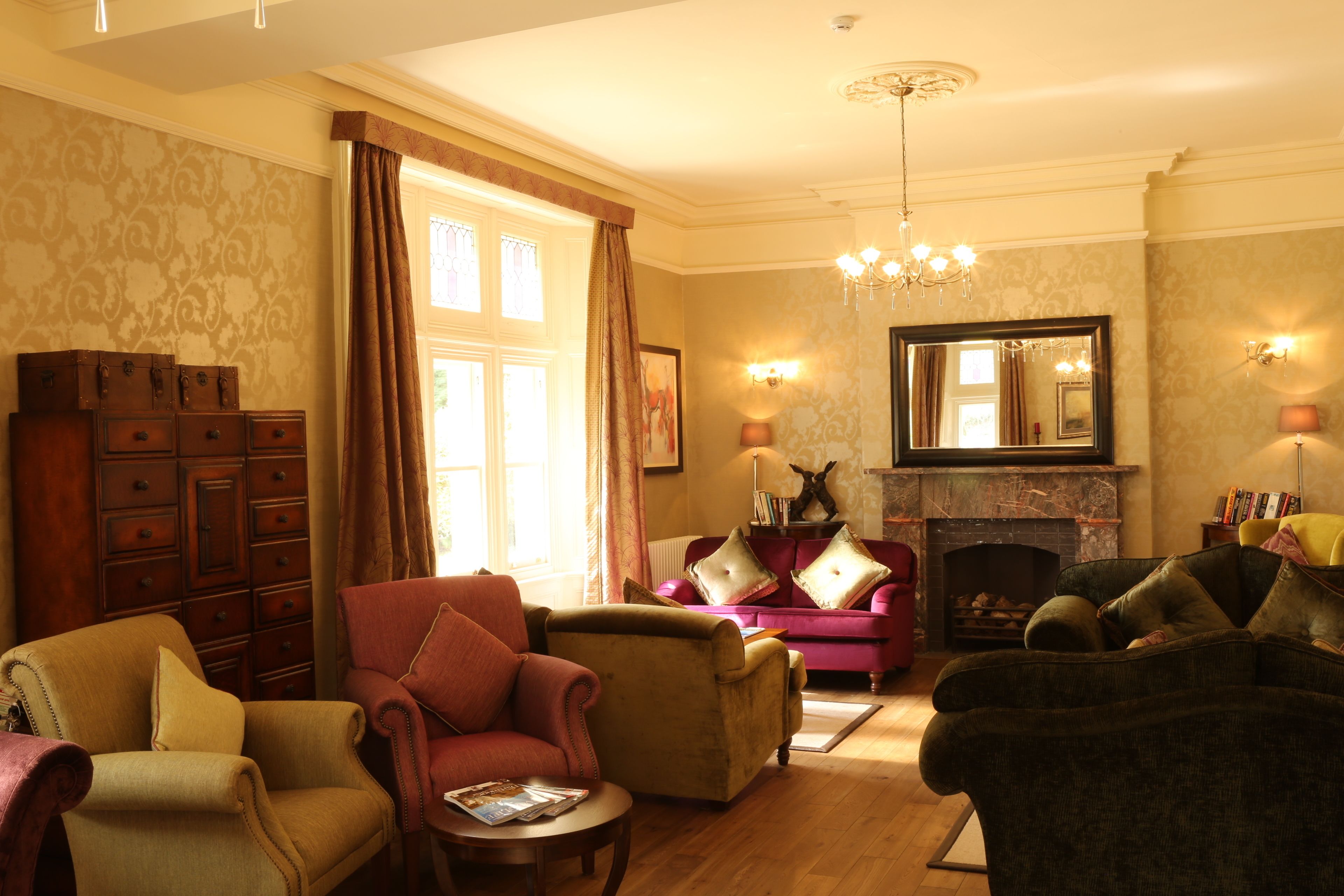 A traditional living room with multiple armchairs, a fireplace, and a large mirror.
