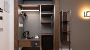 A compact storage unit with shelves, a small refrigerator, and a coffee maker. - Rome Art Hotel - Trevi Hotels Group (Rome)