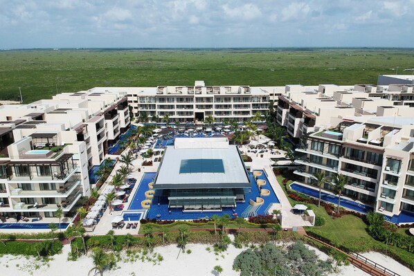 A hotel with multiple floors, a central swimming pool, and a view of the surrounding landscape. - Royalton Hideaway Riviera Cancun, An Autograph Collection All-Inclusive Resort- Adults Only - Newly Renovated (Puerto Morelos)