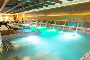 A spa area with multiple hot tubs, a wooden ceiling, and tiled flooring.