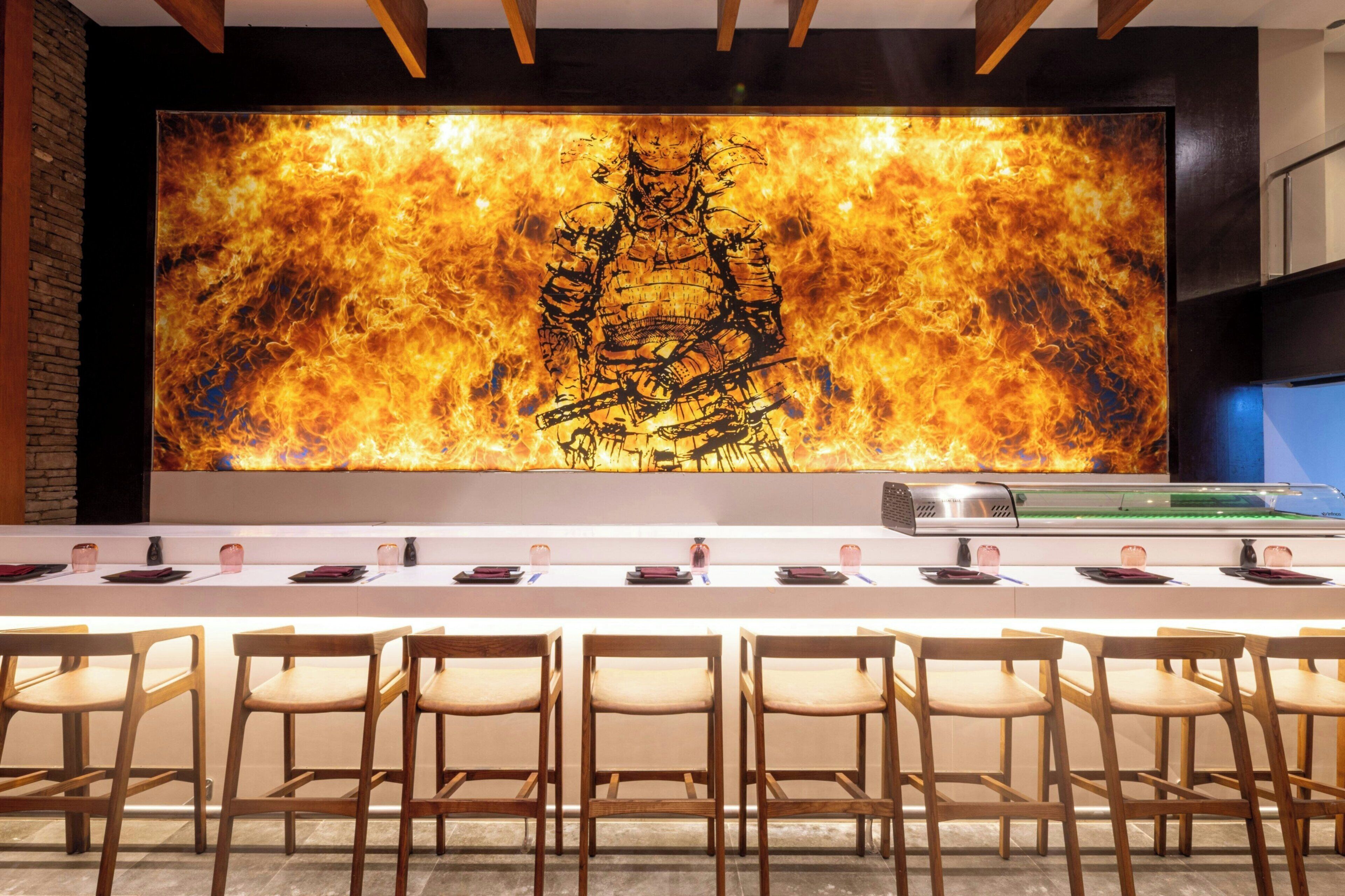 A conference room with a long table, chairs, and a large wall mural.