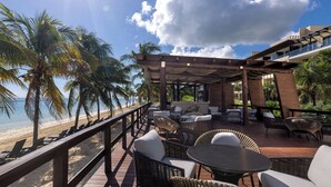 A beachside patio with wicker furniture, a wooden deck, and a view of the ocean. - Royalton Hideaway Riviera Cancun, An Autograph Collection All-Inclusive Resort- Adults Only - Newly Renovated (Puerto Morelos)