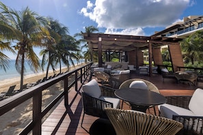 A beachside patio with wicker furniture, a wooden deck, and a view of the ocean. - Royalton Hideaway Riviera Cancun, An Autograph Collection All-Inclusive Resort- Adults Only - Newly Renovated (Puerto Morelos)
