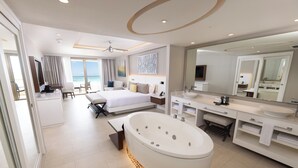 A modern hotel room with a large bed, a bathtub, a vanity with a mirror, and a view of the beach. - Royalton Hideaway Riviera Cancun, An Autograph Collection All-Inclusive Resort- Adults Only - Newly Renovated (Puerto Morelos)