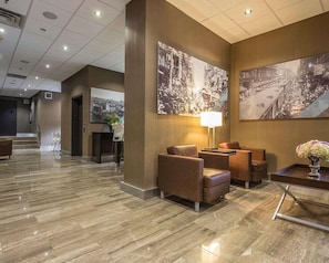 A hotel lobby with a marble floor, leather seating, and large black-and-white photographs on the walls. - The Saint James Hotel, an Ascend Collection Hotel (Toronto)