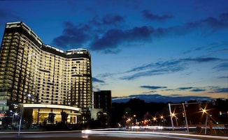 Un hotel de gran altura con fachada curva, varios pisos y ventanas iluminadas.