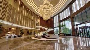 A spacious lobby with a grand chandelier, a central staircase, and a seating area. - DoubleTree by Hilton Hotel Heyuan (Heyuan)