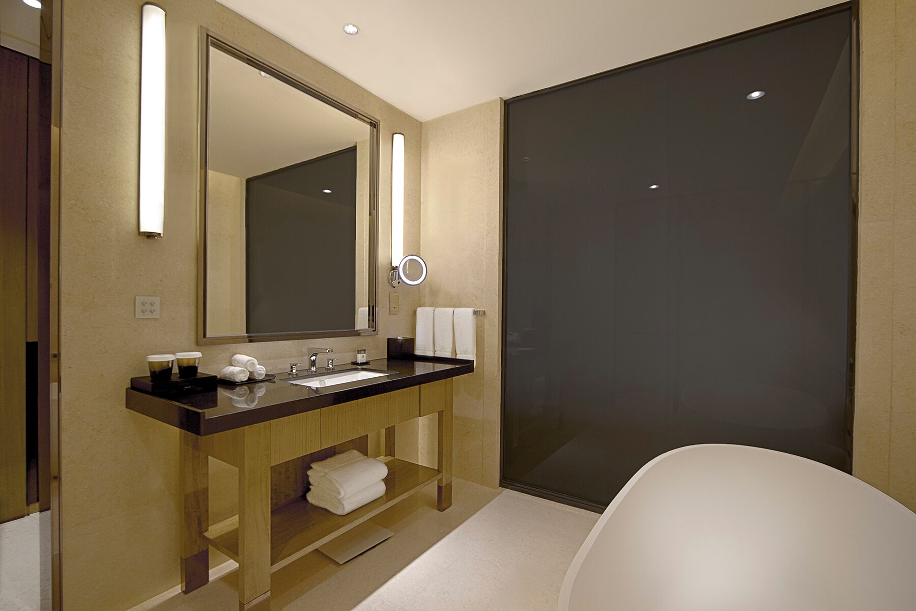 Une salle de bain moderne avec un grand miroir, un lavabo et des toilettes.