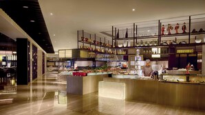 A modern hotel lobby with a polished wooden floor, a central reception desk, and a display of decorative items on shelves. - DoubleTree by Hilton Hotel Heyuan (Heyuan)