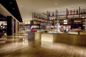 A modern hotel lobby with a polished wooden floor, a central reception desk, and a display of decorative items on shelves. - DoubleTree by Hilton Hotel Heyuan (Heyuan)