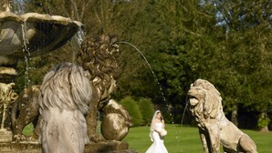 A stone fountain with lions and a bride in the background. - Trump® International Scotland (Aberdeen)