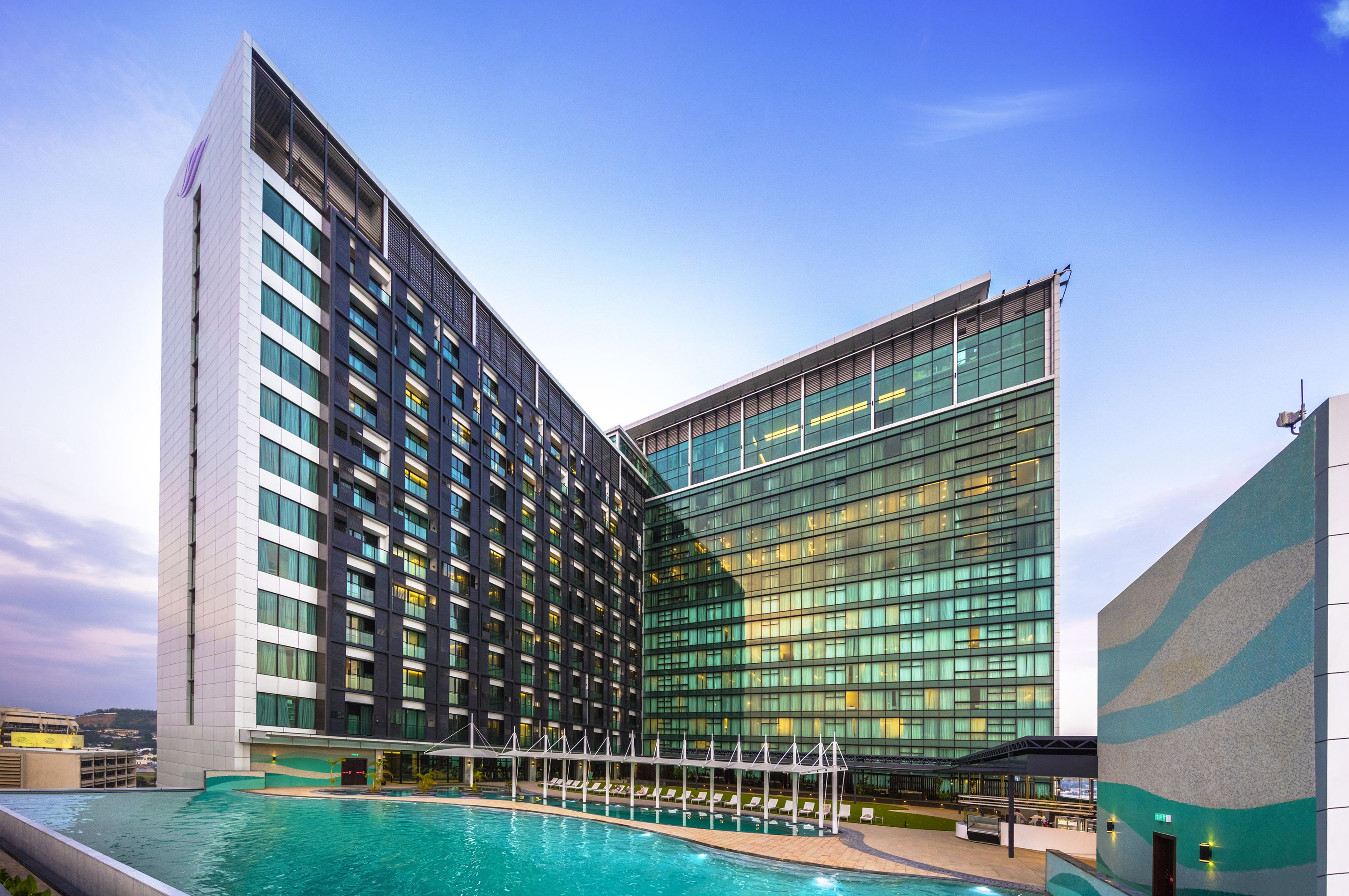 Un hotel moderno con zona de piscina y un amplio ventanal de vidrio.