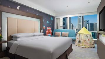 Ein Hotelzimmer mit einem großen Bett, einer Couch, einem Zelt zur Dekoration und Blick auf die Stadt.