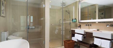 Une salle de bain moderne dotée d’une douche à parois de verre, d’une baignoire sur pieds et d’un meuble-lavabo avec un miroir.