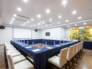 A conference room with a long table, chairs, water bottles, and a projector screen. - Novotel Nanjing Central Suning (Nanjing)
