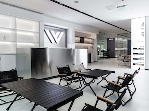 A modern fitness center with a minimalist design, featuring black exercise equipment, a large logo on the wall, and a reception area. - Novotel Nanjing Central Suning (Nanjing)