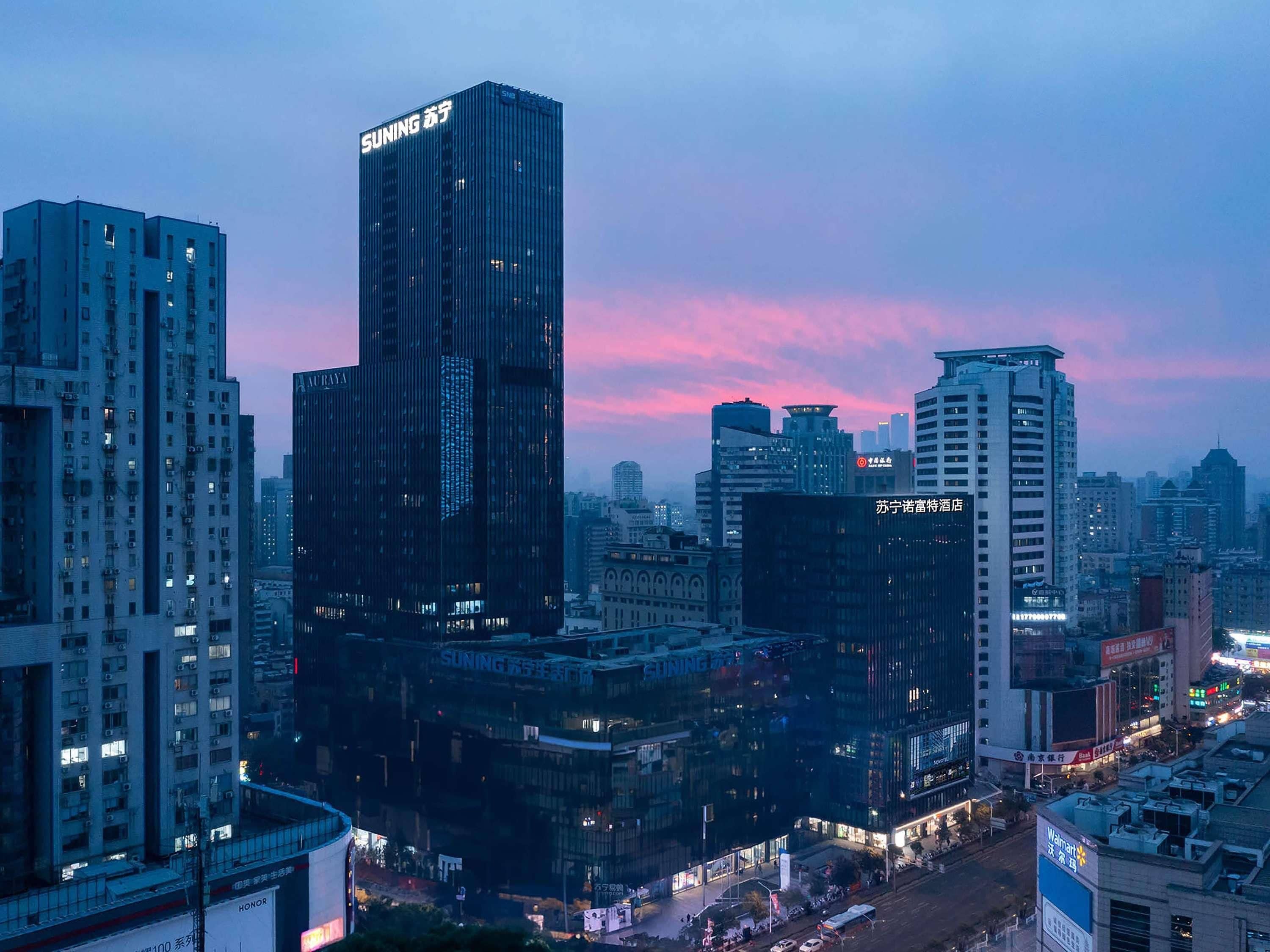 A cityscape with modern high-rise buildings, including a prominent building with 'SUNING' signage.