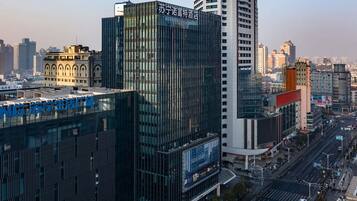 A modern hotel with a glass facade and signage in a cityscape.
