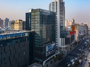 A modern hotel with a glass facade and signage in a cityscape. - Novotel Nanjing Central Suning (Nanjing)
