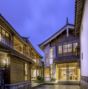 A traditional wooden building with a courtyard, large windows, and a sign reading "LUX".