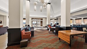 A spacious lobby with a central seating area, a wooden table, and a patterned carpet. - Hilton Garden Inn Findlay (Findlay)