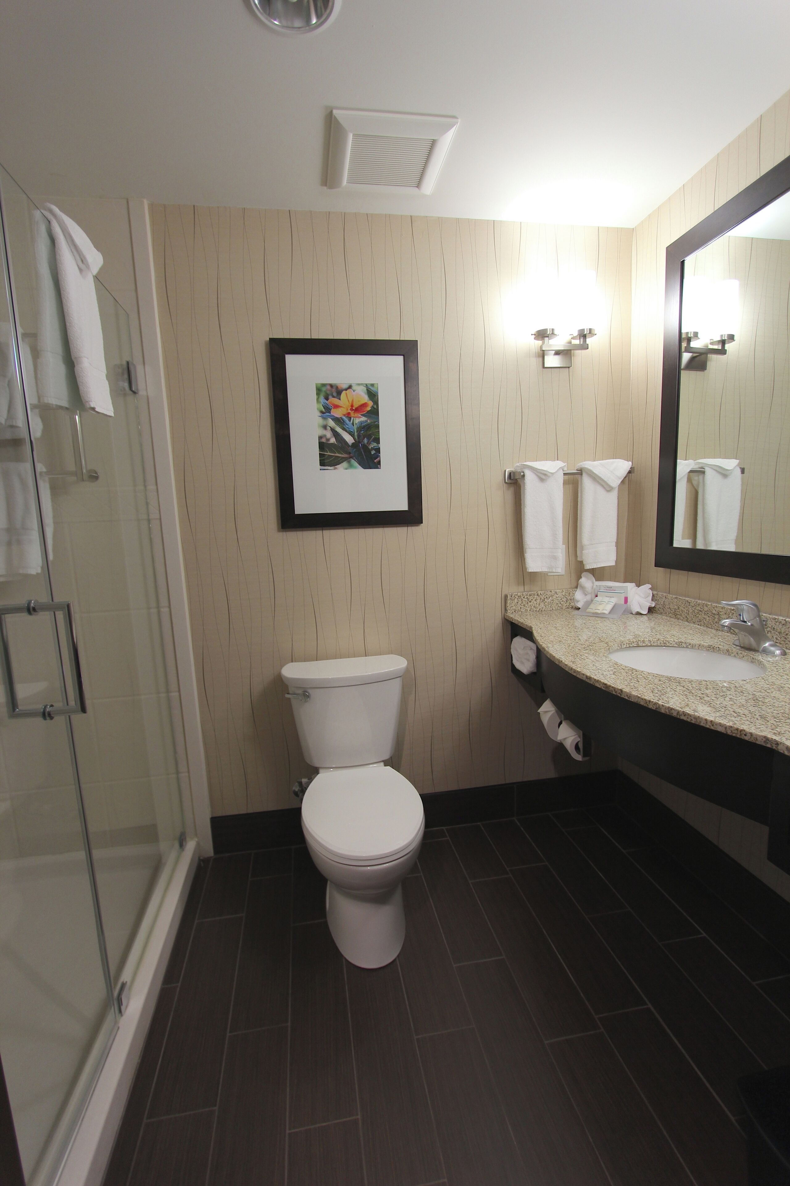 A modern bathroom with a toilet, sink, and shower.