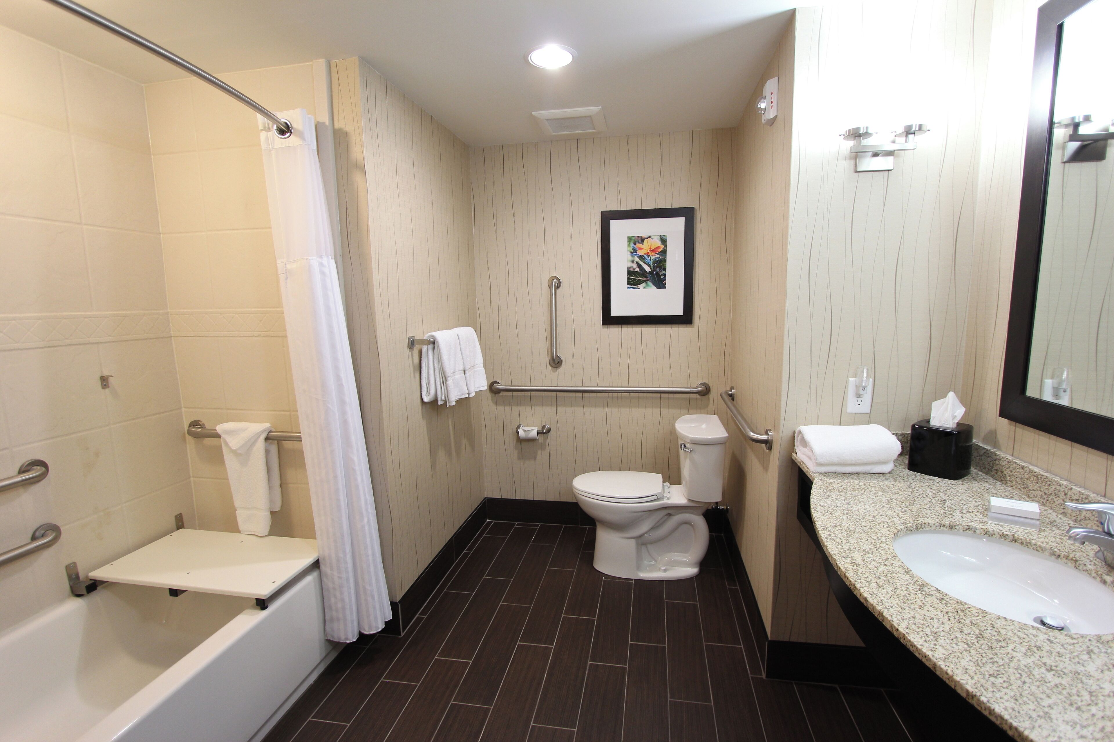 A modern bathroom with a bathtub, toilet, and sink.