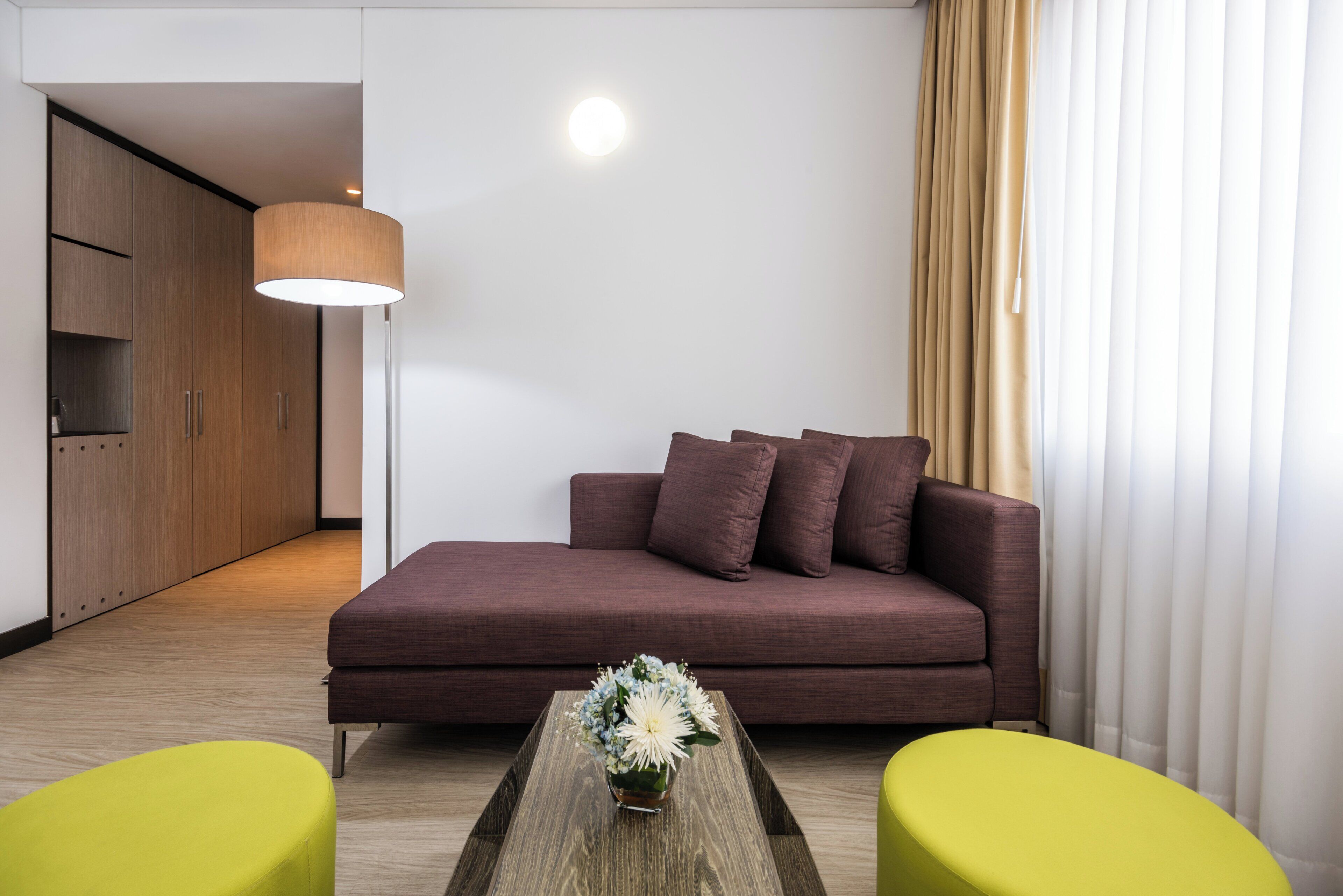 Uma sala de estar moderna com um sofá, duas poltronas, uma mesa de centro e um abajur.