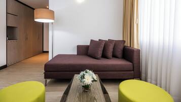 Uma sala de estar moderna com um sofá, duas poltronas, uma mesa de centro e um abajur.